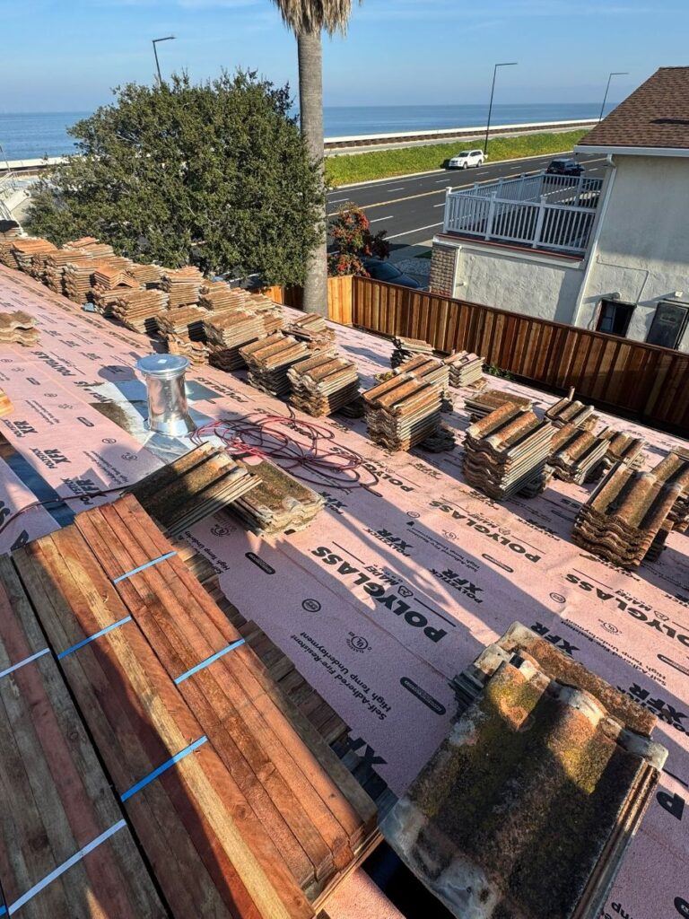 Terracotta tiles staged over underlayment during a roof replacement